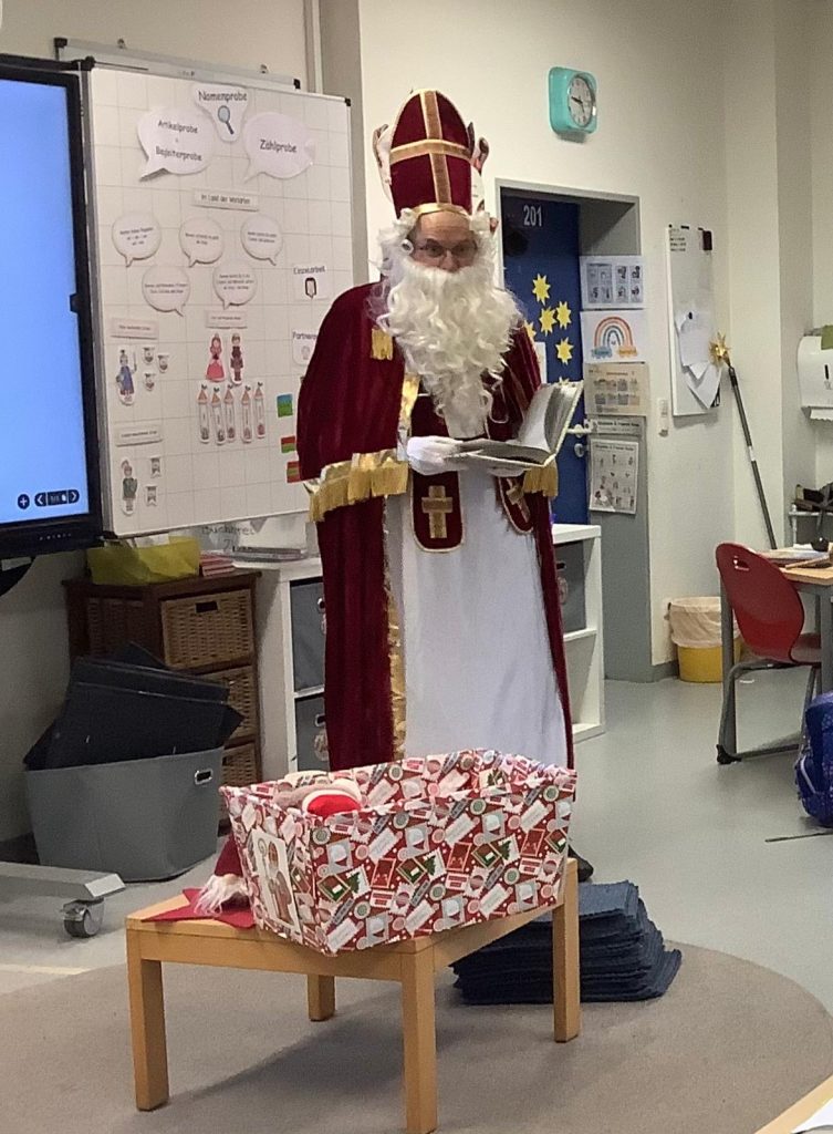 Nikolaus steht vor Tafel und liest aus seinem goldenen Buch, 2025 &copy; S.Hirschberg